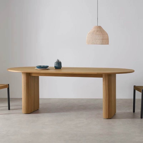 Solid Oak Oval Ribbed Dining Table with two chairs in a minimalistic room.