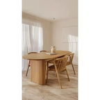 Dining area with Solid Oak Oval Ribbed Dining Table and chairs in a minimalistic room.