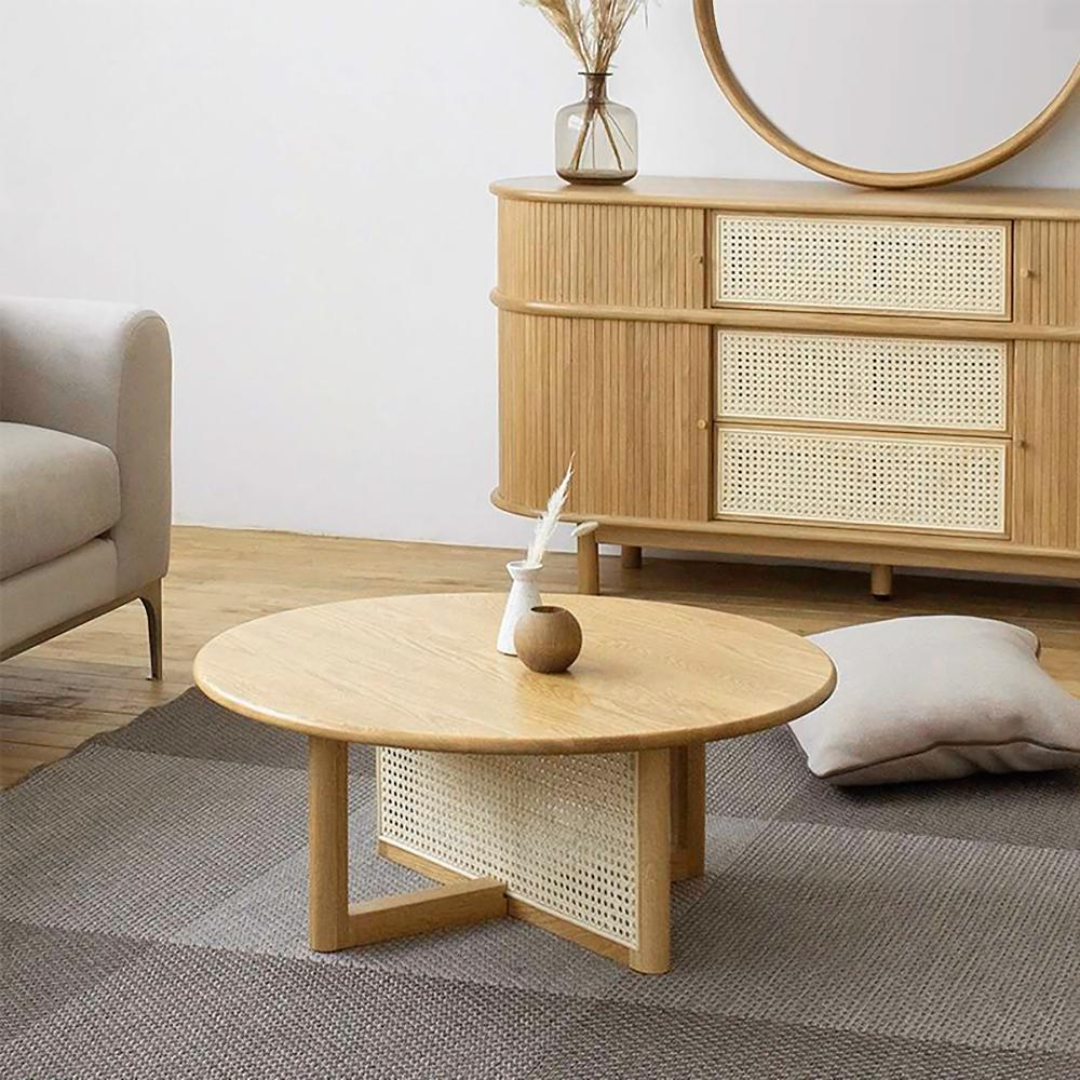 Living room with Rattan Round Coffee Table and dresser, beige sofa, and round mirror.