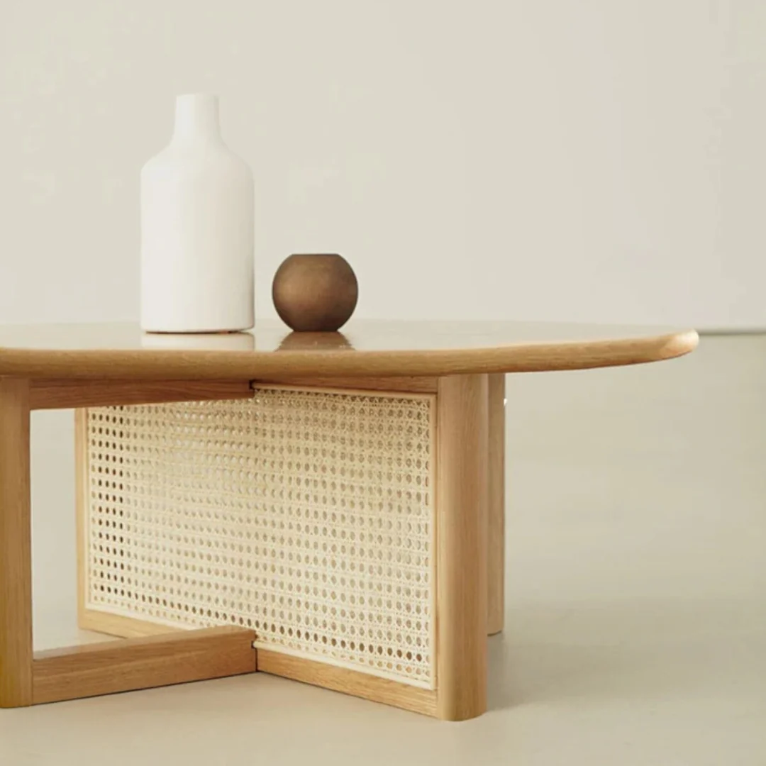 Rattan Round Coffee Table with wicker shelf and decorative items on a neutral background