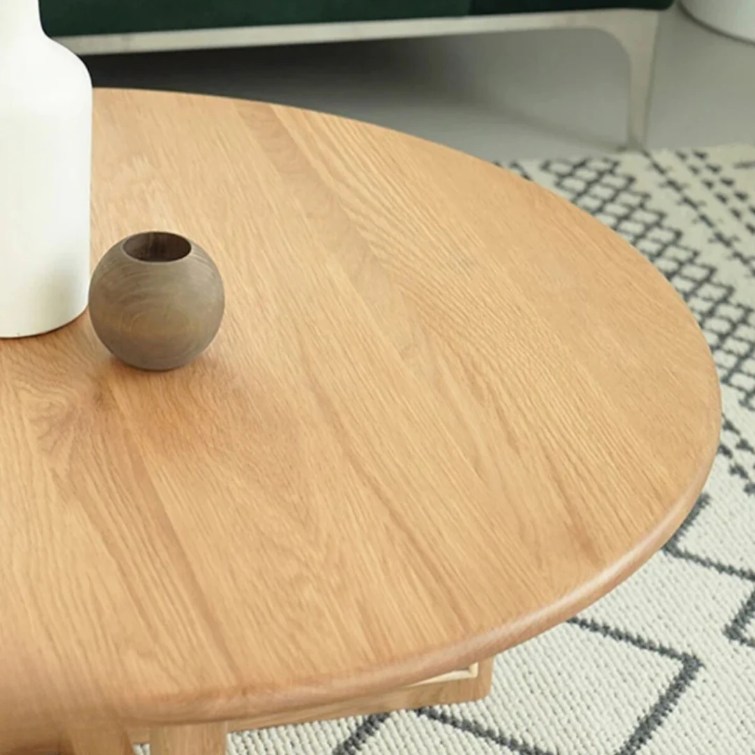 Rattan Round Coffee Table with a small round vase on a patterned rug