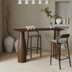Modern dining area with a wooden bar table and wooden bar stools in a minimalistic setting.
