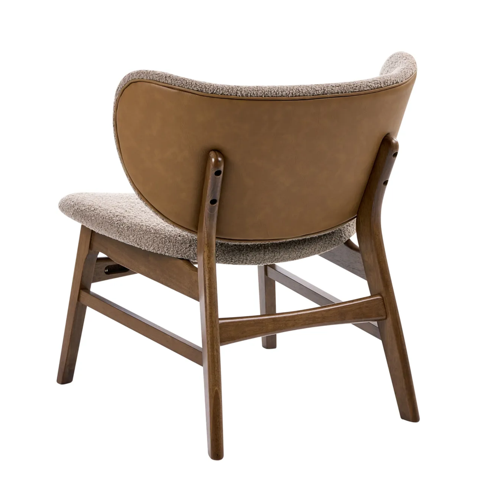A mid-century modern accent chair shown from the back, featuring a curved tan leather backrest, a textured beige bouclé seat and backrest trim, and a medium brown wooden frame.