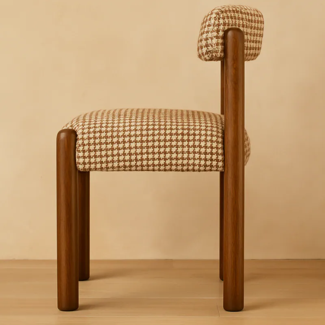 Chair with wooden legs and houndstooth patterned cushion on a beige background
