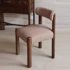Chair with brown wooden frame and patterned cushion on a light wooden floor.