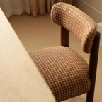 Brown and beige patterned chair with wooden frame in a room setting