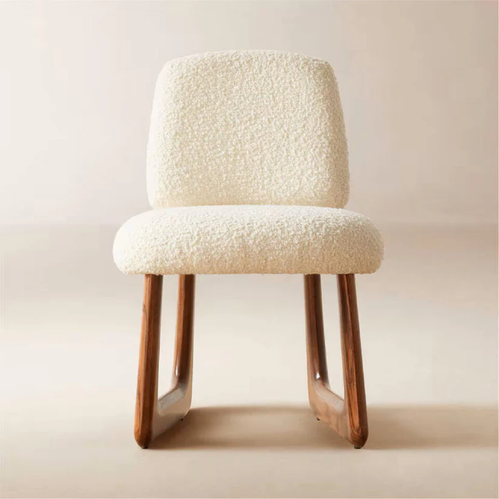 Neutral Boucle Dining Chair with textured white cushion and wooden legs on a plain background