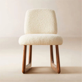 Neutral Boucle Dining Chair with textured white cushion and wooden legs on a plain background