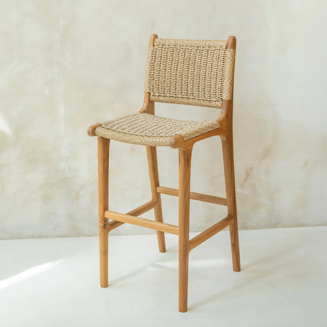 Wooden bar stool with rattan backrest and seat against a light background