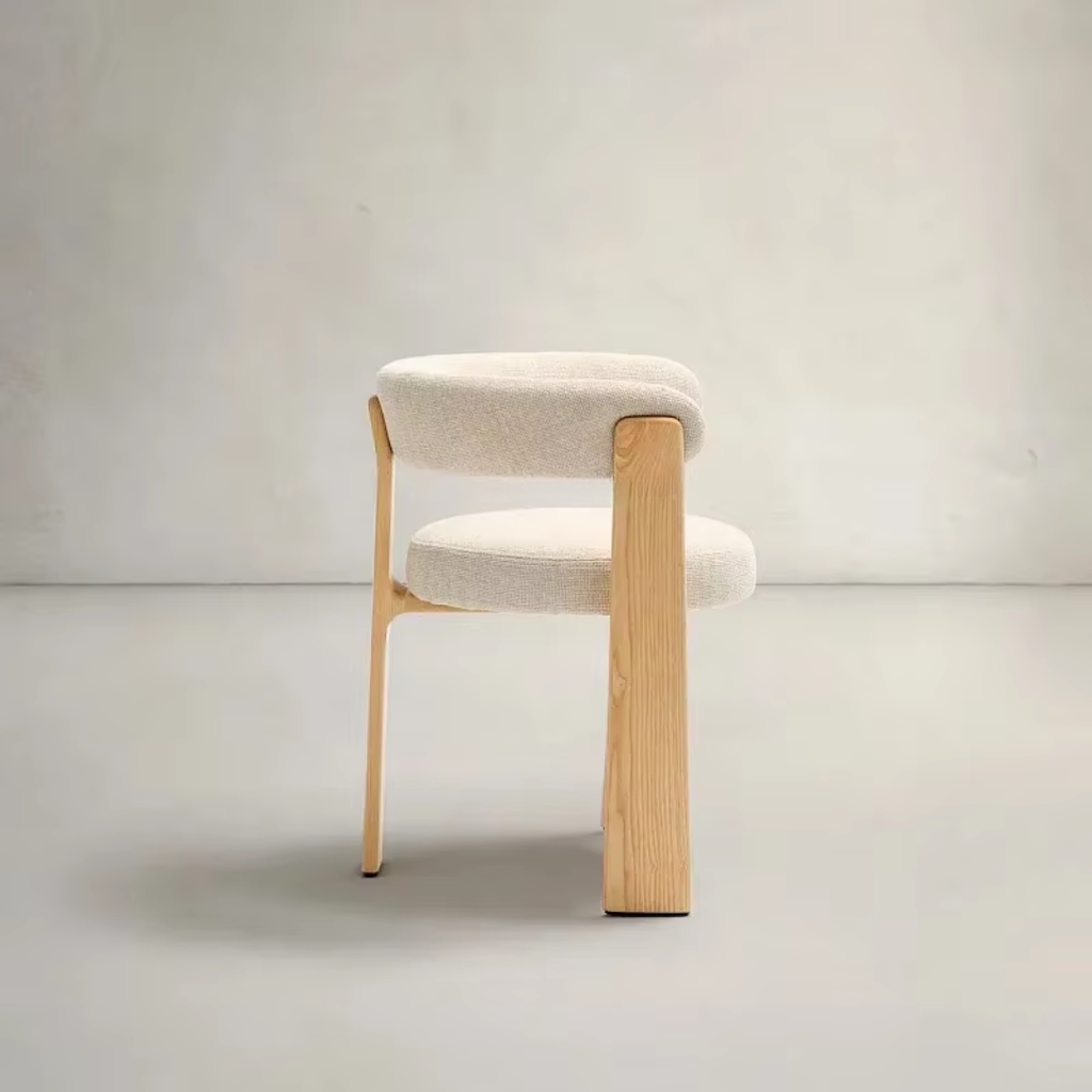 Cream Fabric And Oak Dining Chair with wooden legs and beige cushioned seat on a plain background