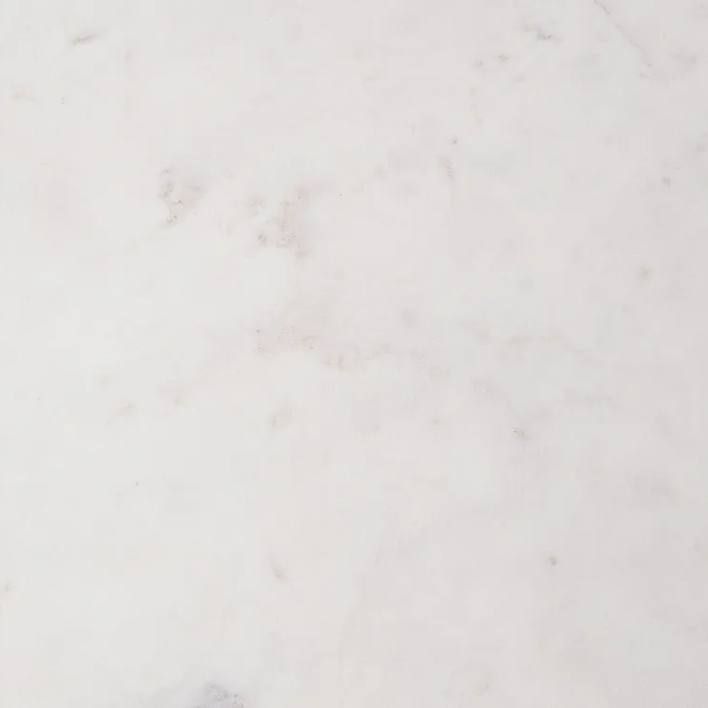 A close-up of a white marble or quartz surface with subtle light gray veining and a smooth, polished texture.