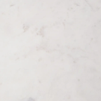 A close-up of a white marble or quartz surface with subtle light gray veining and a smooth, polished texture.