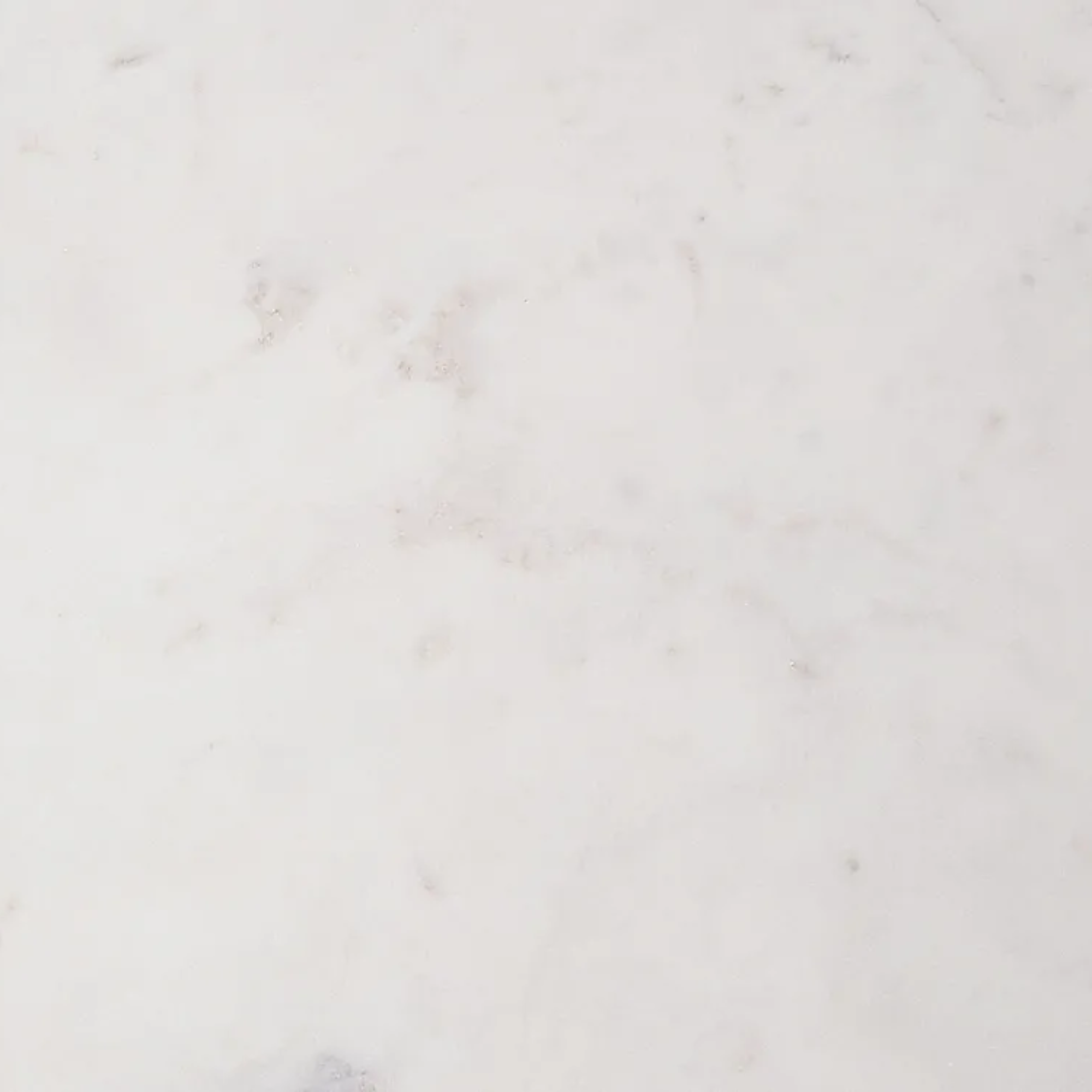 A close-up of a white marble or quartz surface with subtle light gray veining and a smooth, polished texture.