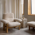 Bouclé Lounge Chair with Wood Frame in a room with light curtains and a window.