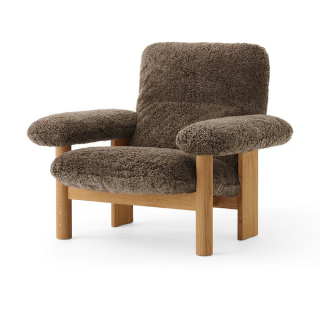 Brown upholstered armchair with wooden legs on a white background
