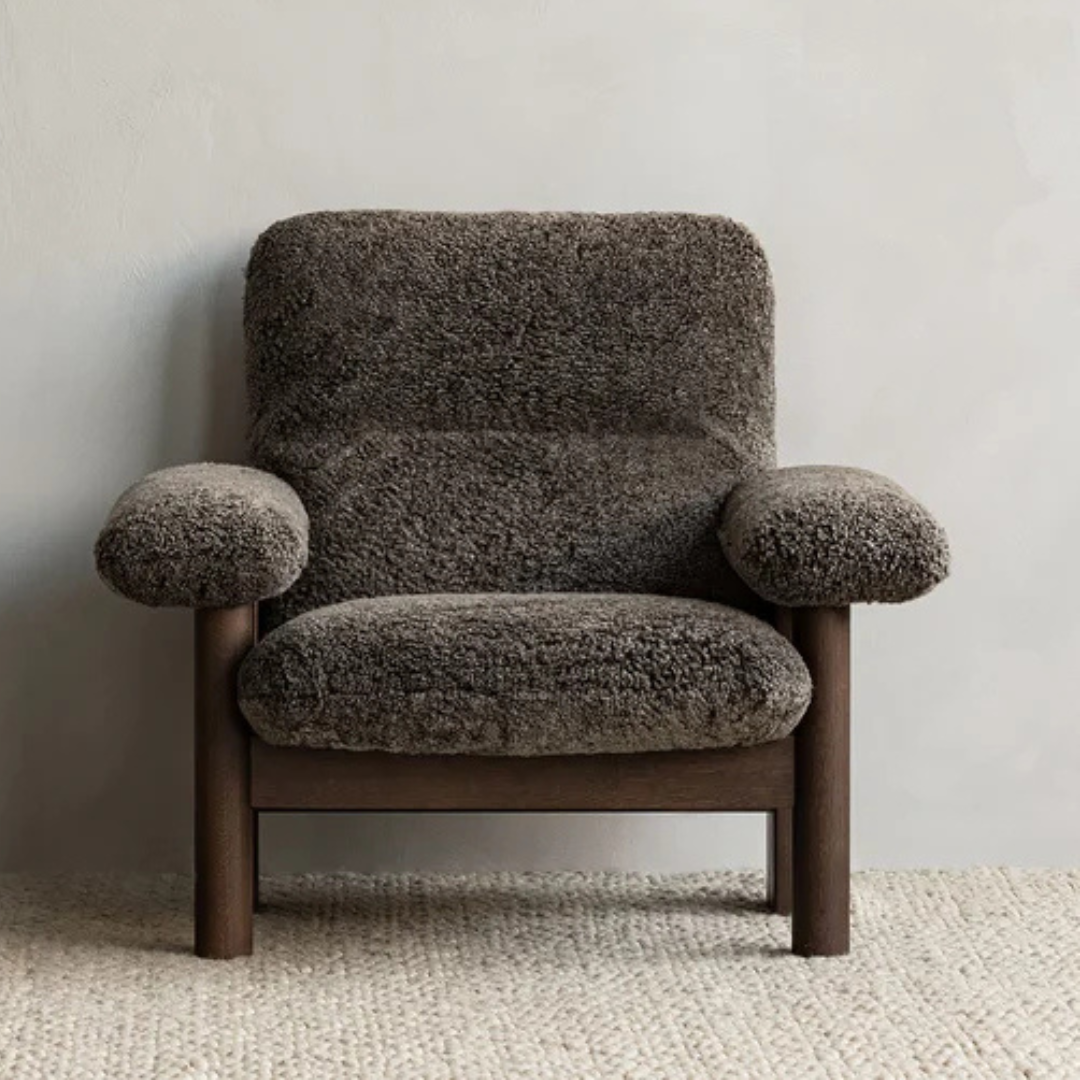 Brown textured armchair against a plain wall