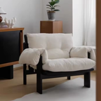 White Corduroy Armchair with Black Wood Frame in a room with a wooden cabinet and plant.
