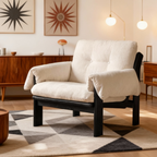 White corduroy chair with black frame in a room with wooden furniture and abstract art on the wall.