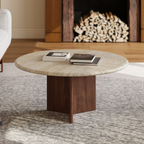 Round coffee table with a wooden base in a living room setting.