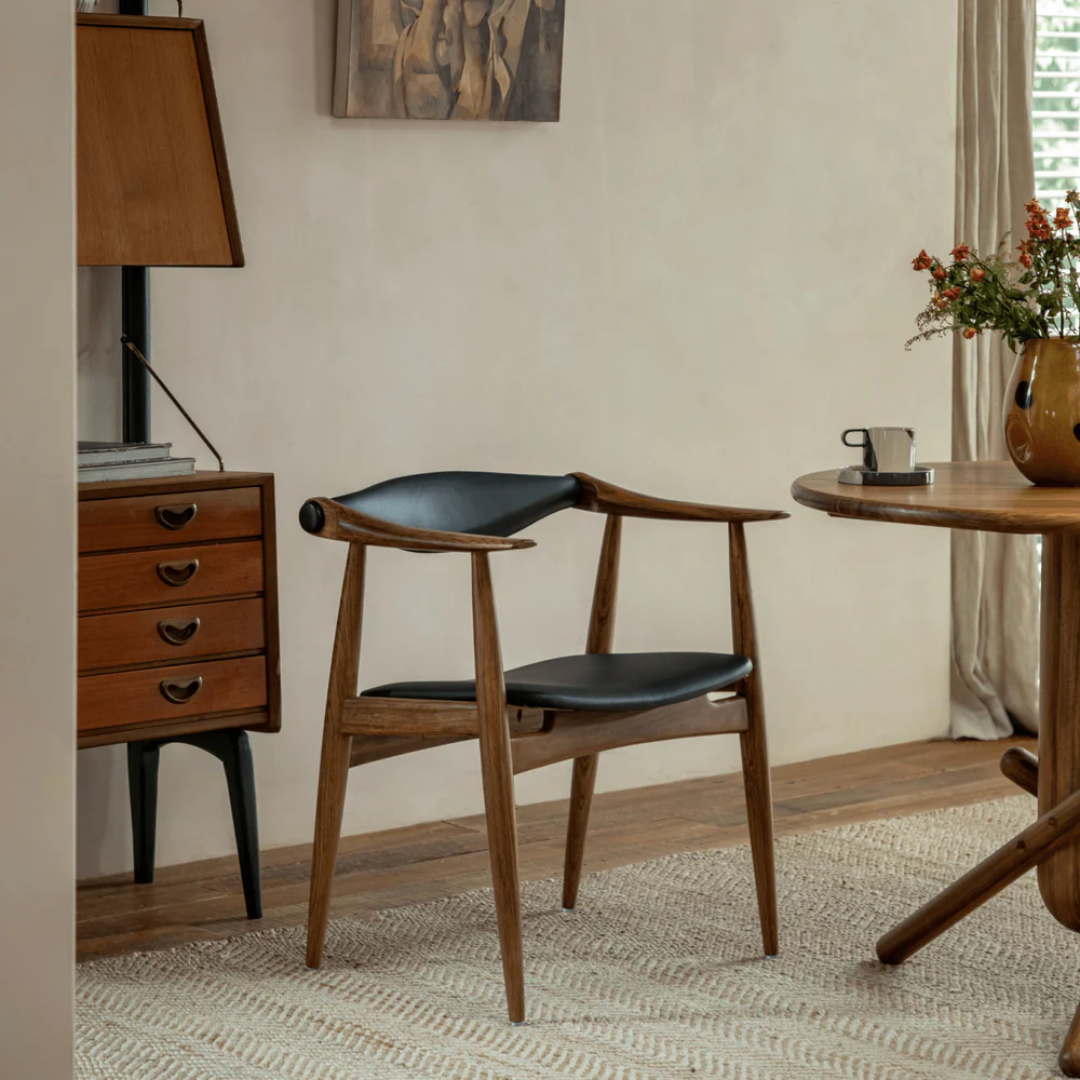 Wood And Black Leather Dining Chair in a room with a lamp, table, and decor.