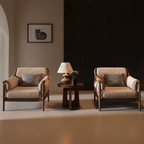 Two beige Cushioned ArmchairS with cushions in a dimly lit room.