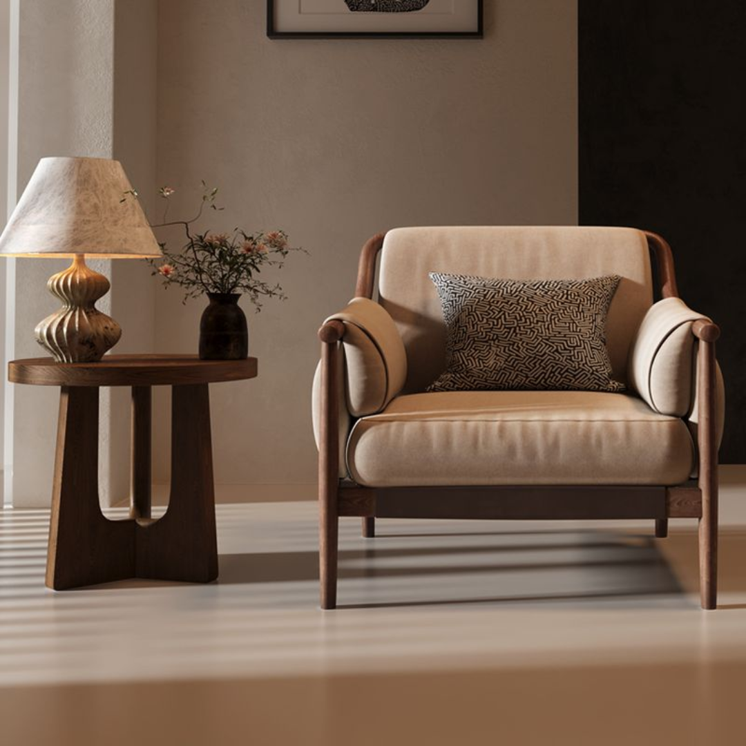 Beige Cushioned Armchair with a decorative pillow in a room with a side table and lamp.