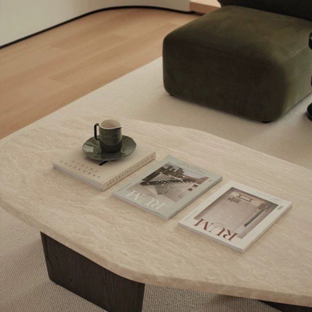 Walnut Wood Round Travertine Coffee Table with books and a cup on a neutral background