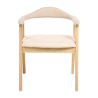 A modern dining chair with a light natural wood frame and plush cream-colored fabric upholstery on the seat and curved backrest, shown against a solid white background.