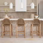 Three wooden bar stools with woven seats in a modern kitchen.