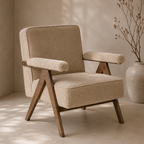 A modern upholstered accent chair with textured beige bouclé fabric and angled dark wood legs, set in a warm neutral room next to a large ceramic vase with dried branches.