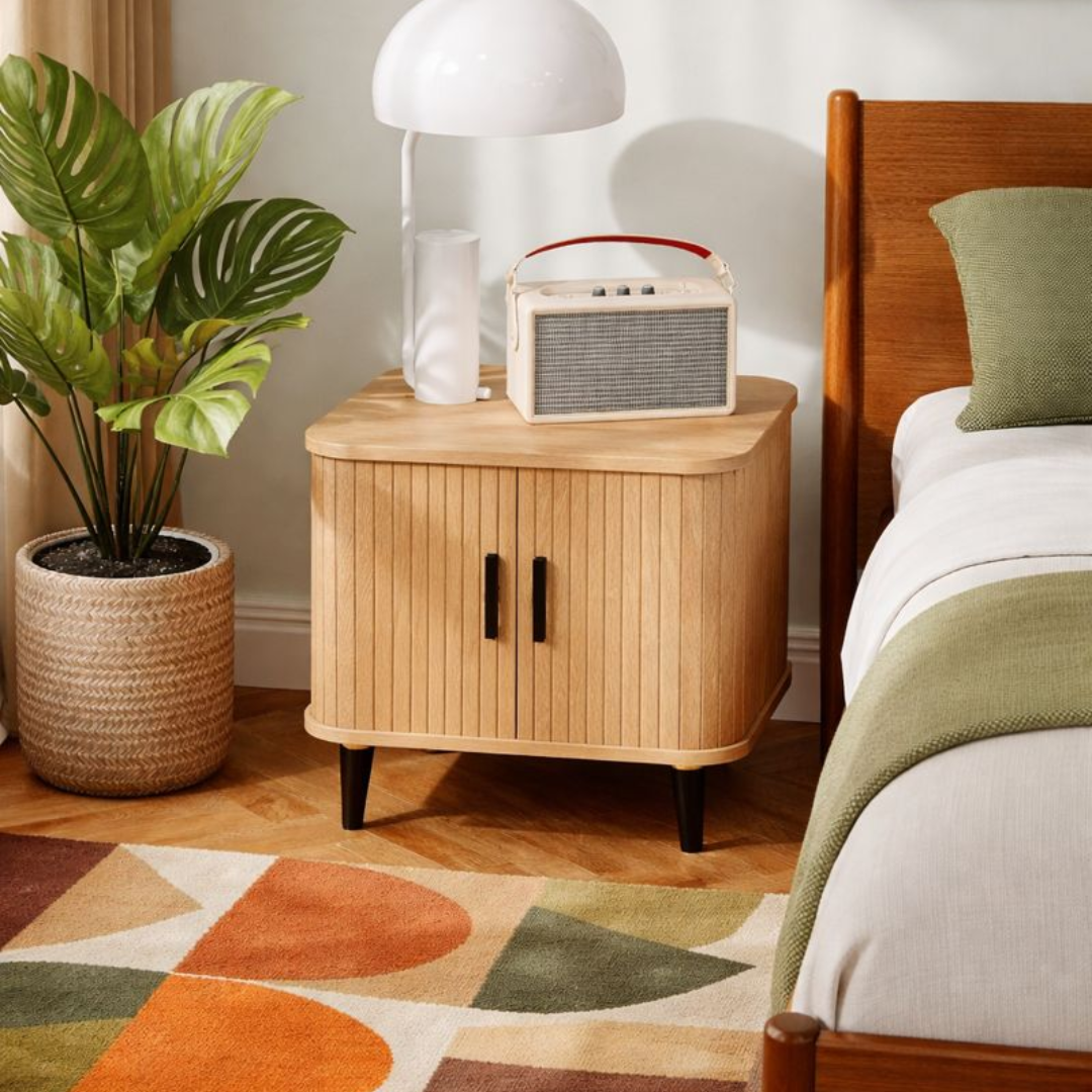 Light Oak Ribbed Bedside Table with a radio, plant, and lamp in a bedroom setting.