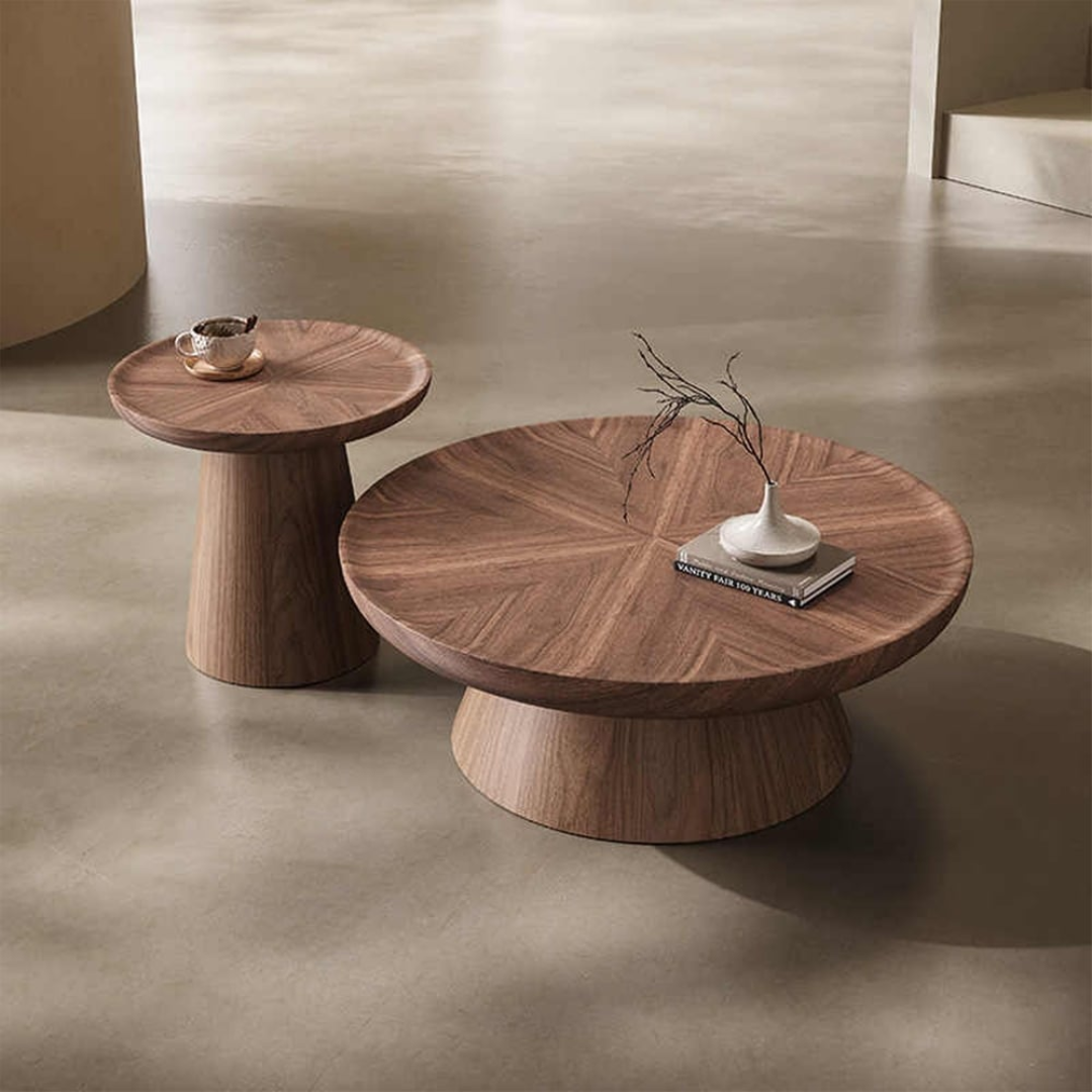 Pedestal Nest Of Wooden Coffee Tables with decorative items on a neutral background