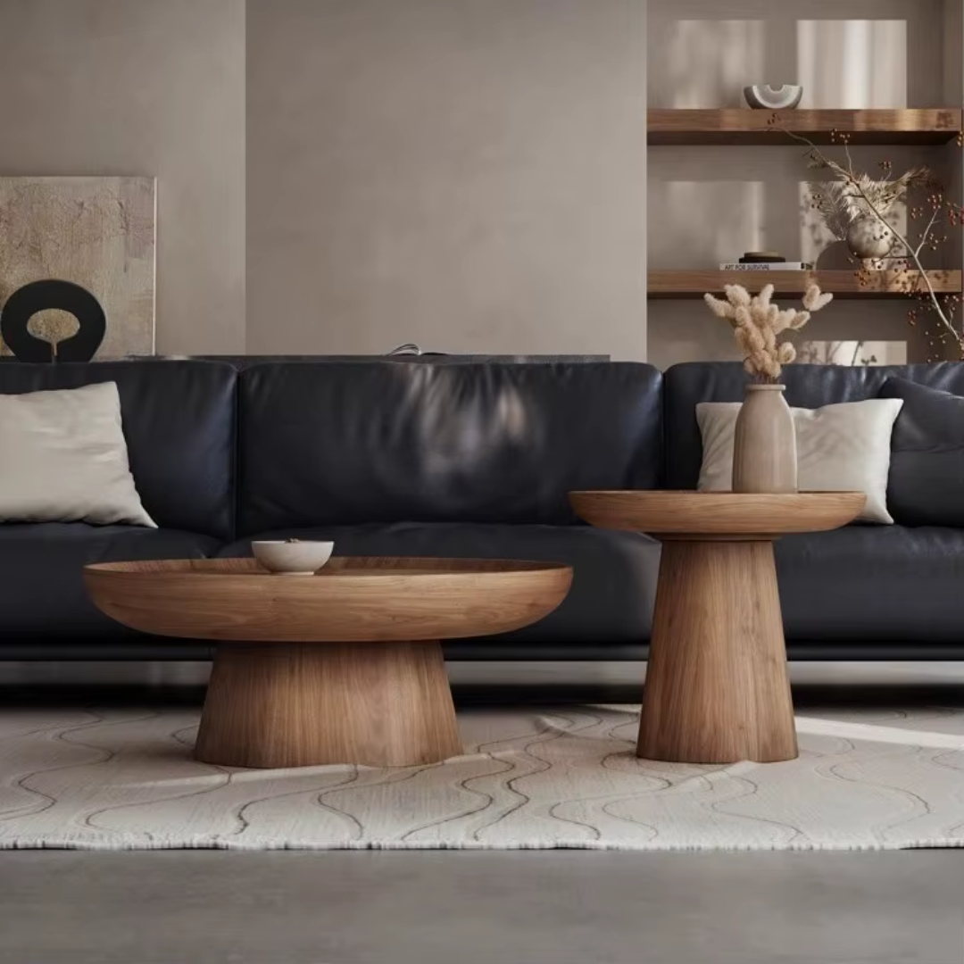 Modern living room with a dark leather sofa, Pedestal Nest Of Wooden Coffee Tables , and decorative elements.