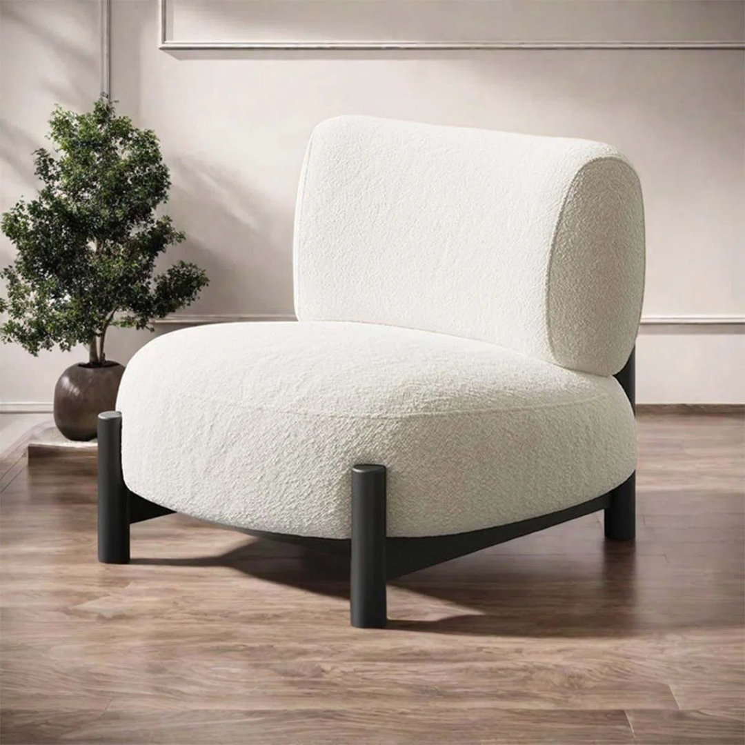 White And Black Accent Chair with black legs in a room with a plant and neutral decor.