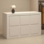 small reception desk in neutral cream finish styled in modern salon or retail interior space