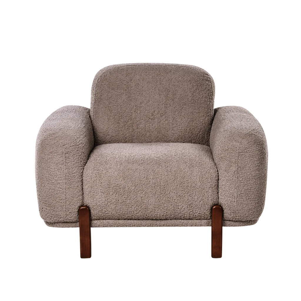 A modern boucle armchair in a warm taupe-grey colour, featuring dark brown wooden legs, shown against a plain white background.