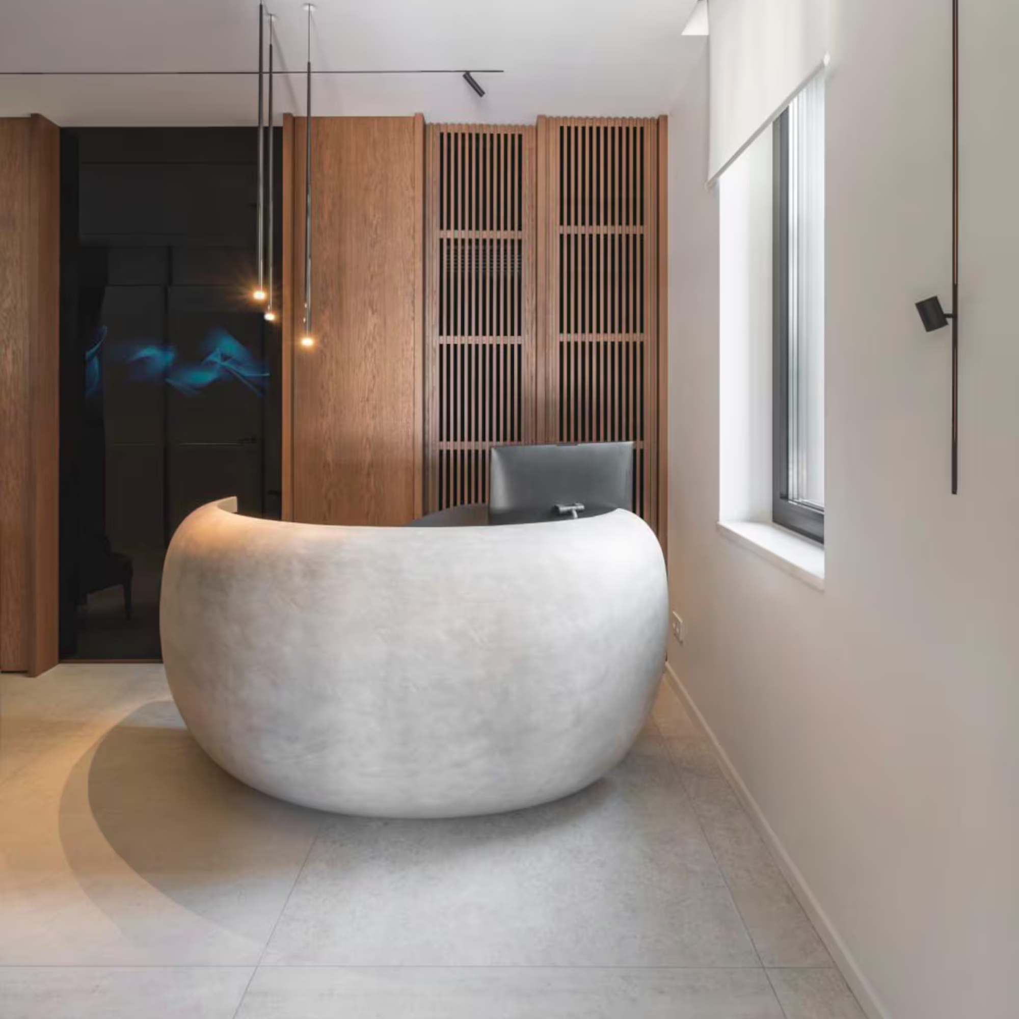 Modern interior with a round concrete desk in a room with wooden paneling and a window.