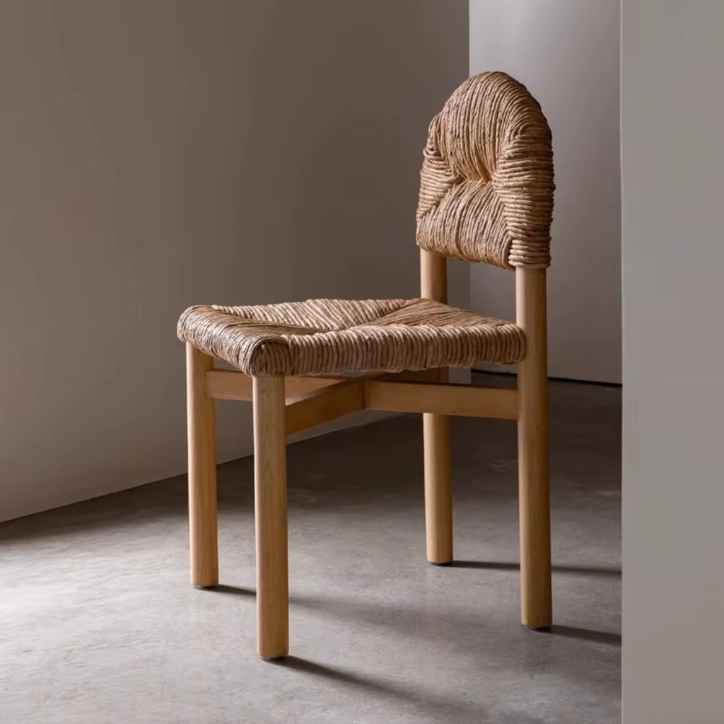 Woven chair with wooden frame against a plain wall