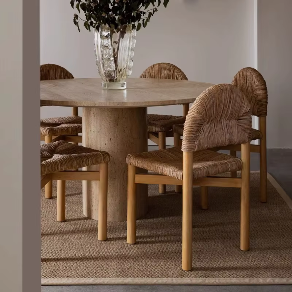 Dining table with woven chairs in a room setting