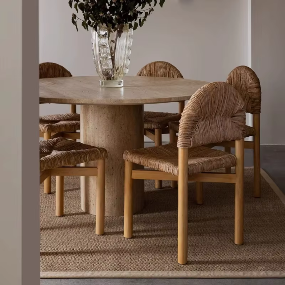Dining table with woven chairs in a room setting