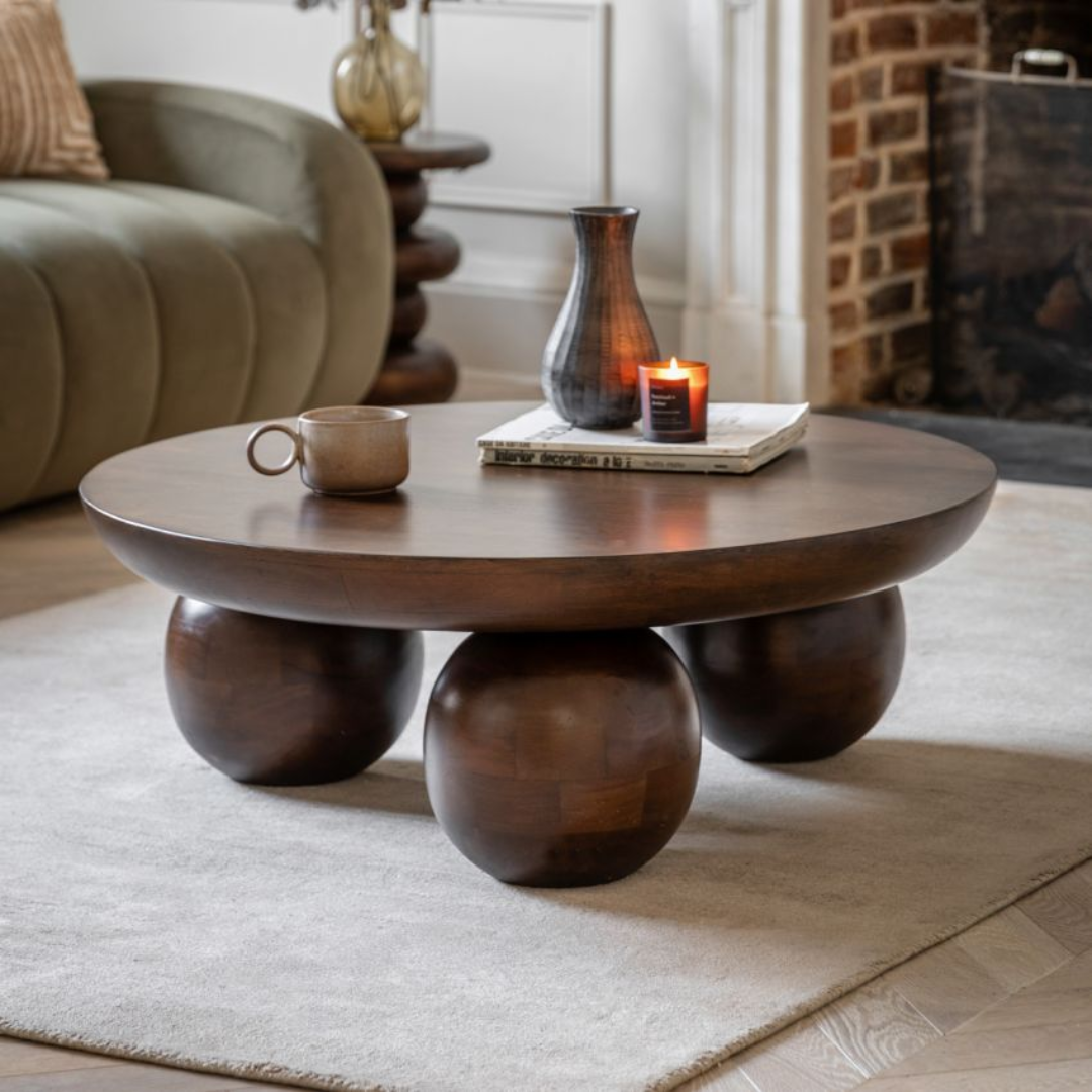 Walnut Round Coffee Table with decorative items in a living room setting