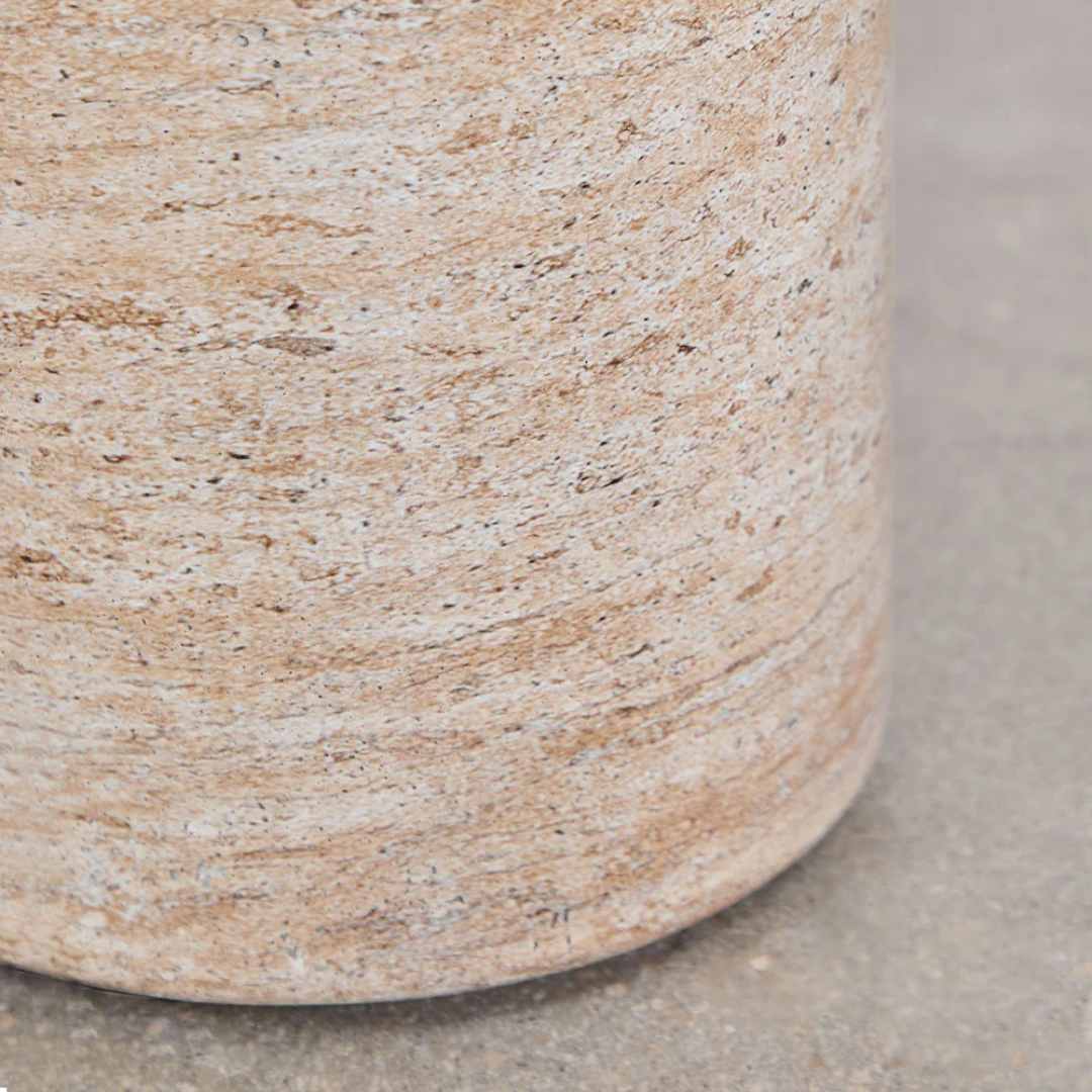 Close-up of a Round Travertine Dining Table on a neutral background
