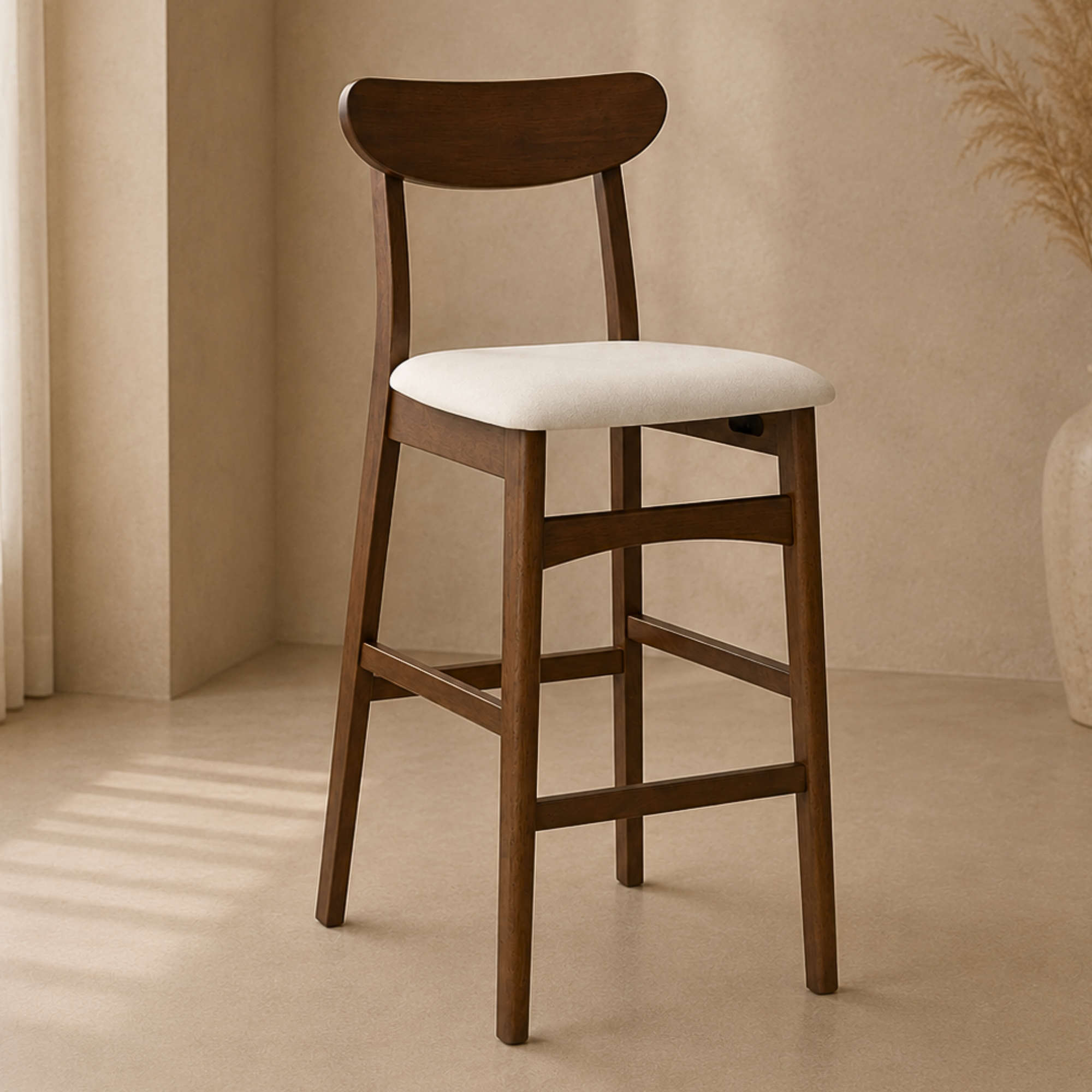 A wooden bar stool with a curved backrest and a cream-colored upholstered seat, set in a warm, minimalist interior with beige walls and floor.
