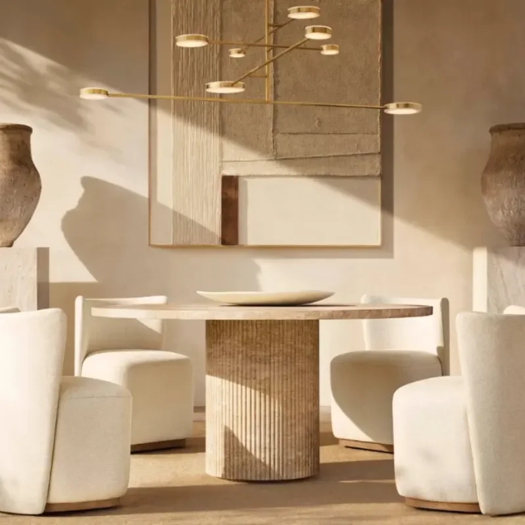 Modern dining room with a Travertine Dining Room Table and chairs, featuring a chandelier and framed artwork.