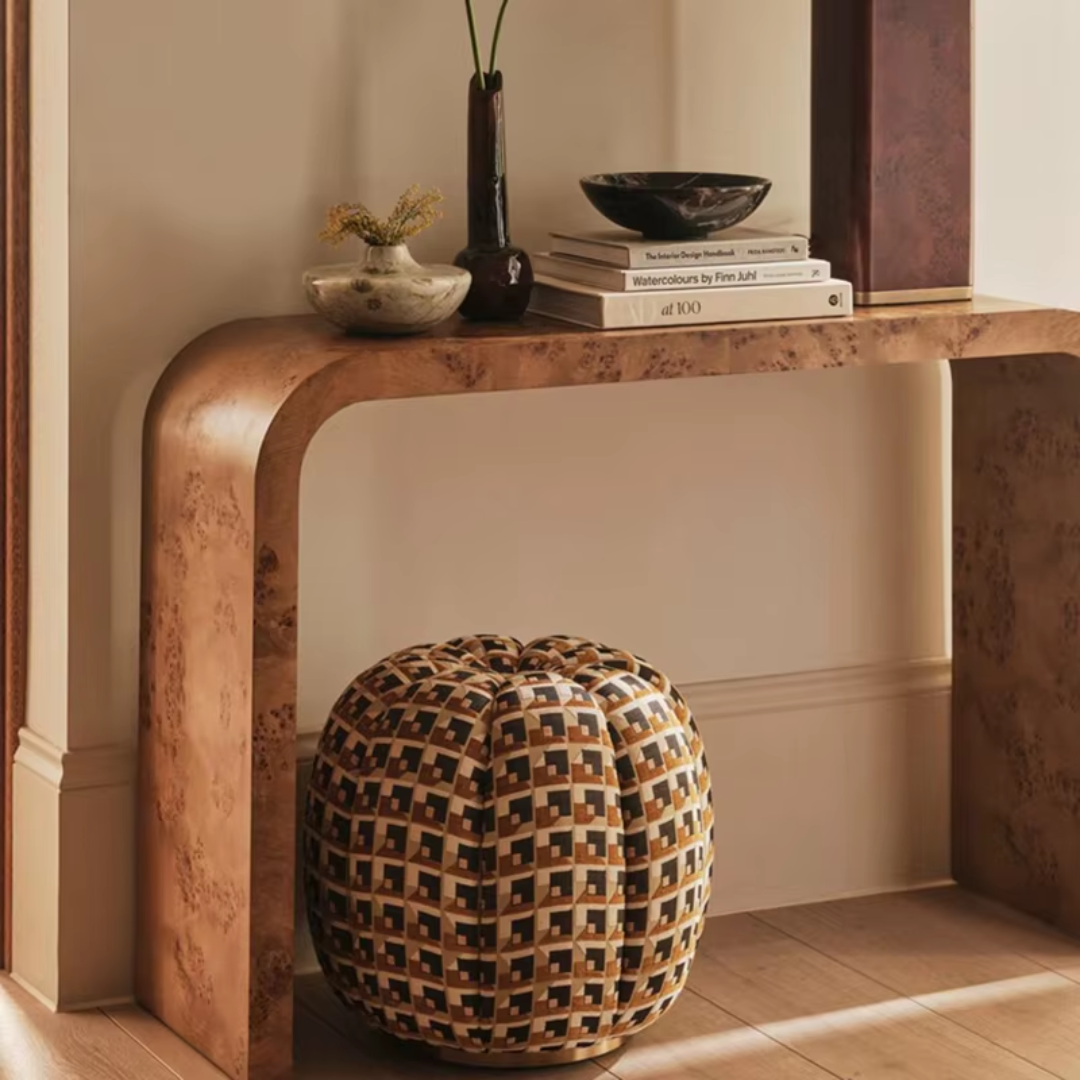 Decorative console table with a patterned pumpkin and books against a neutral wall.
